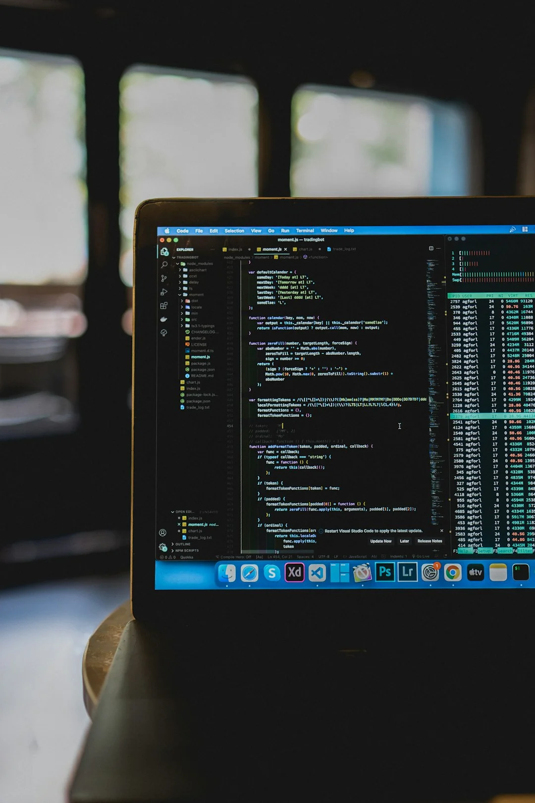 Close-up of hands typing on a laptop next to a cup of coffee on a wooden desk.